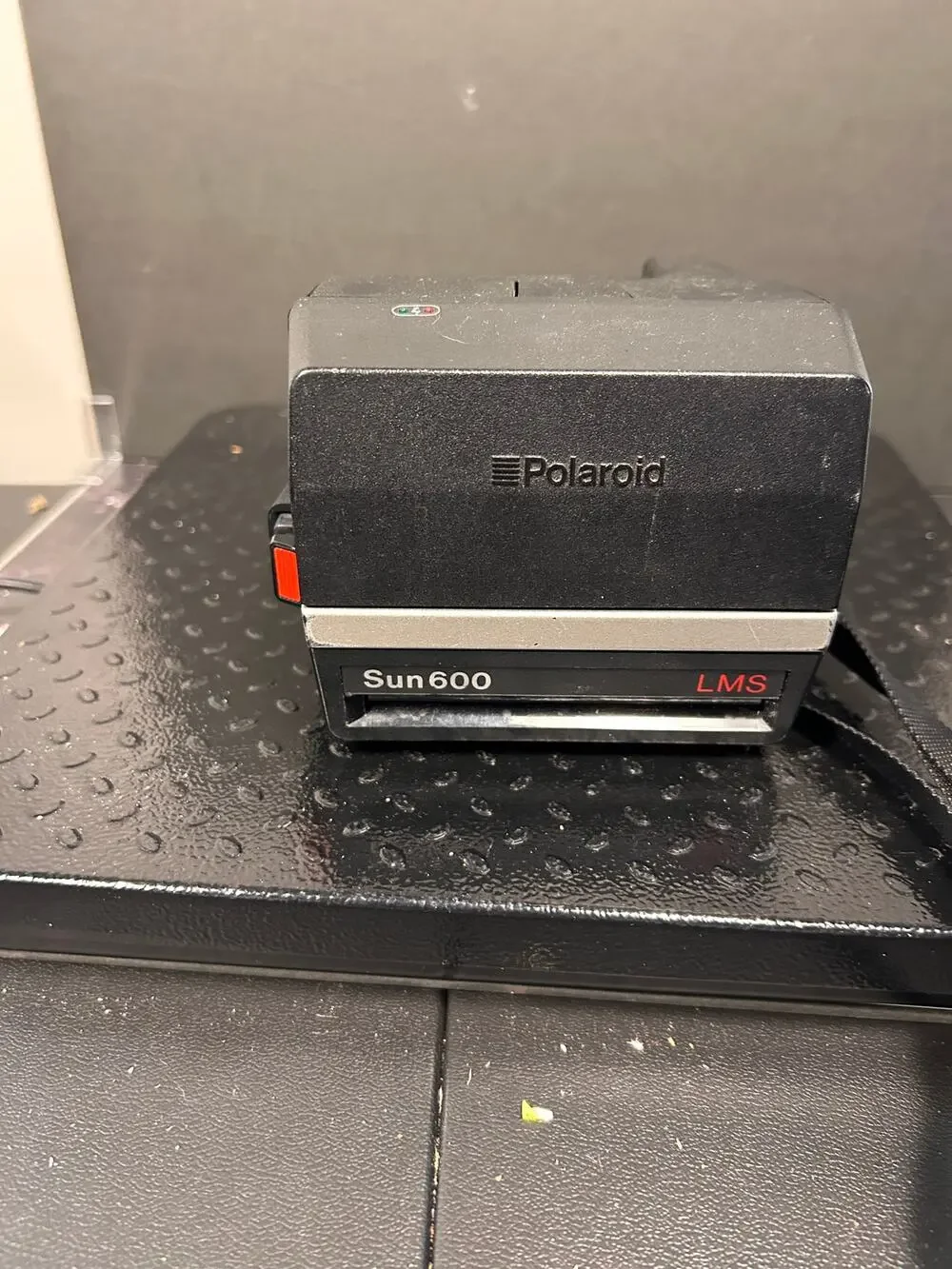 vintage Polaroid Sun 600 LMS instant film camera with red